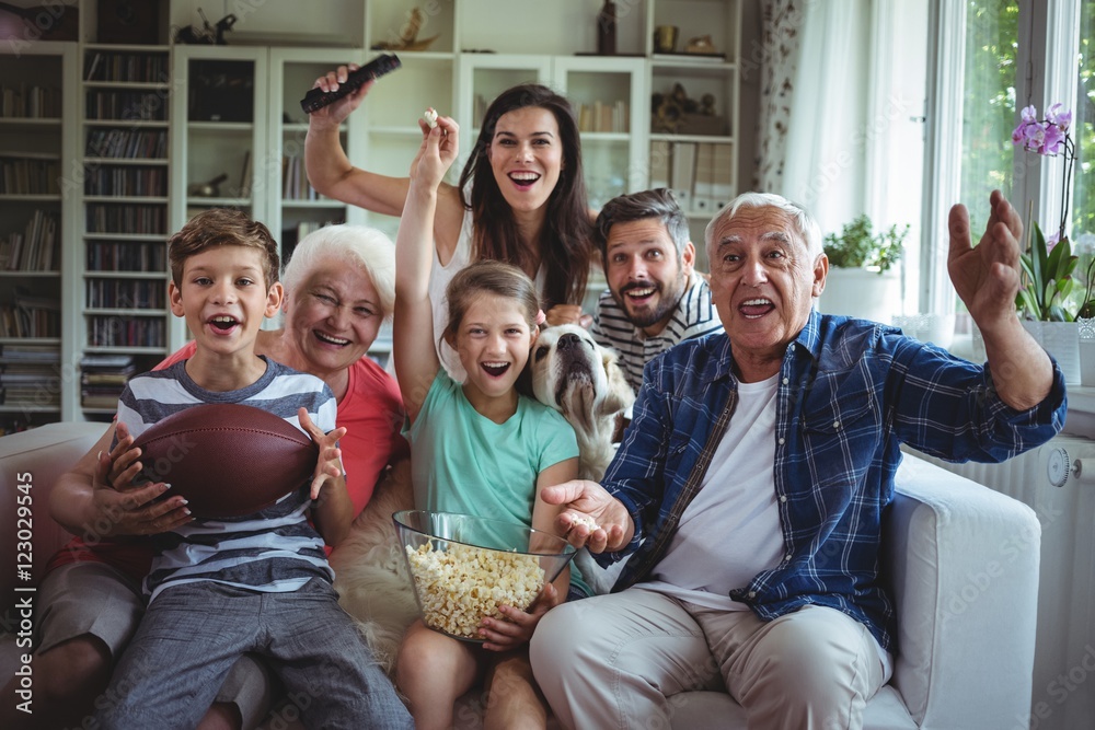 快乐的一家人在电视上观看足球比赛