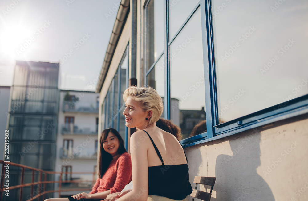三个年轻女人坐在阳台上