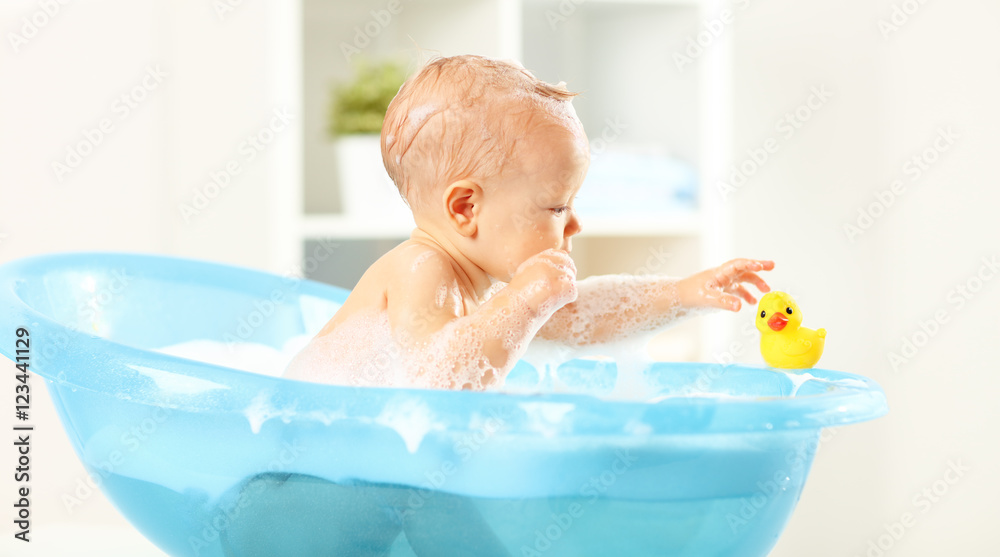 快乐的蹒跚学步的孩子在浴缸里洗澡
