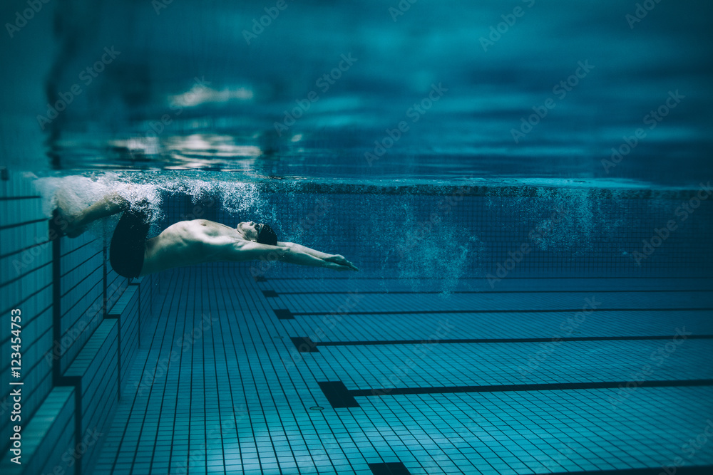 男子游泳运动员在游泳池中翻身