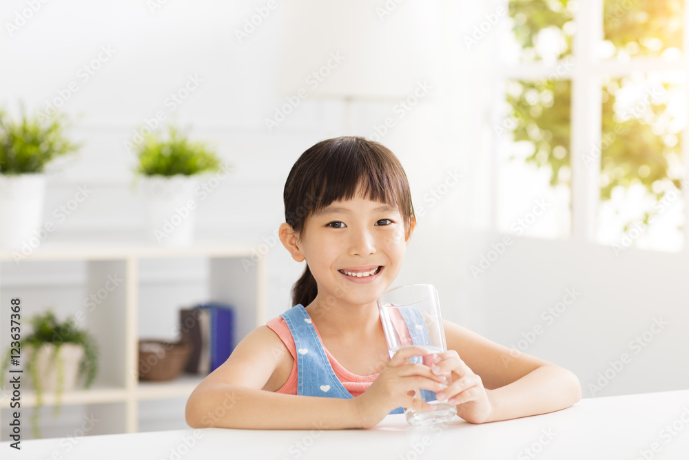 快乐的孩子用玻璃喝水