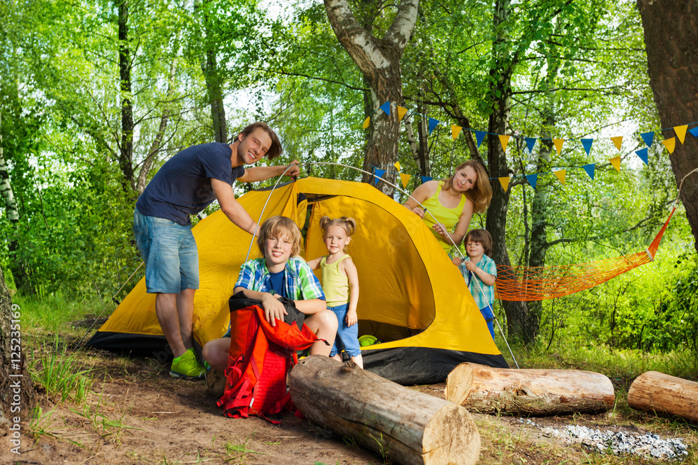 快乐的一家人在露营旅行中搭帐篷