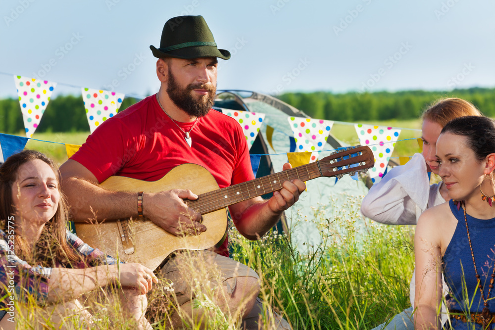 年轻人在营地为朋友弹吉他