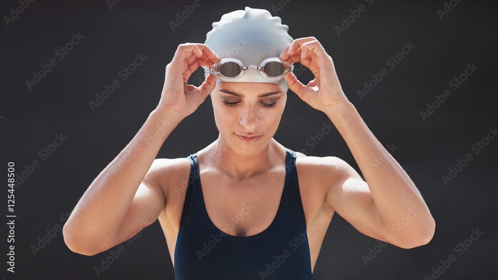 穿着泳衣调整护目镜的女游泳运动员