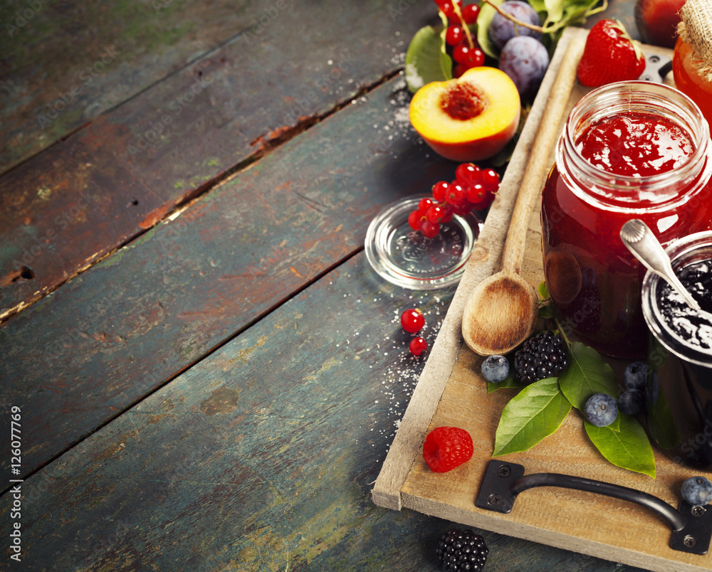 木制背景上的水果和浆果果酱