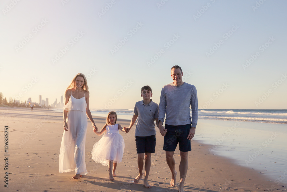 海滩上的四口之家肖像，非常柔和的选择性聚焦，调色