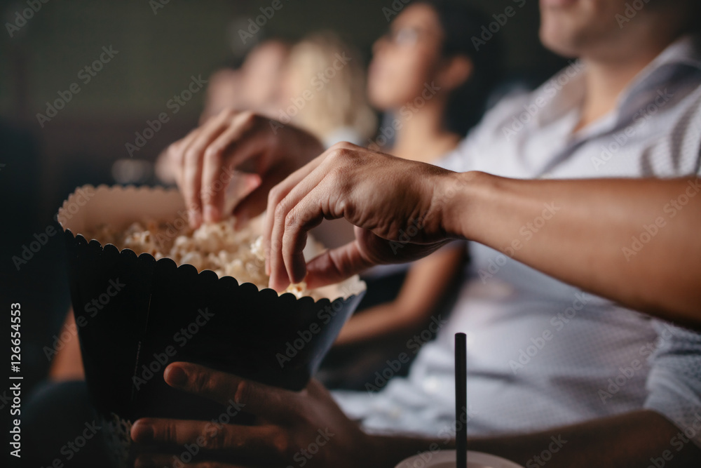 年轻人在电影院吃爆米花