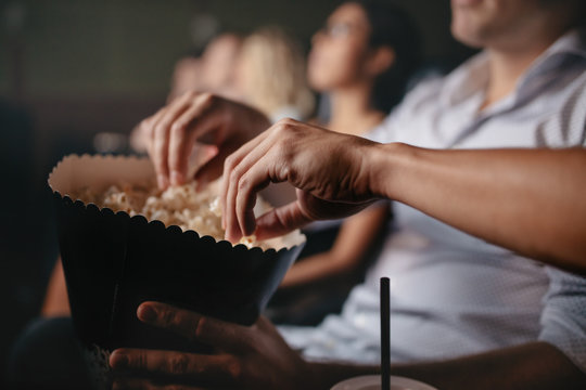 年轻人在电影院吃爆米花