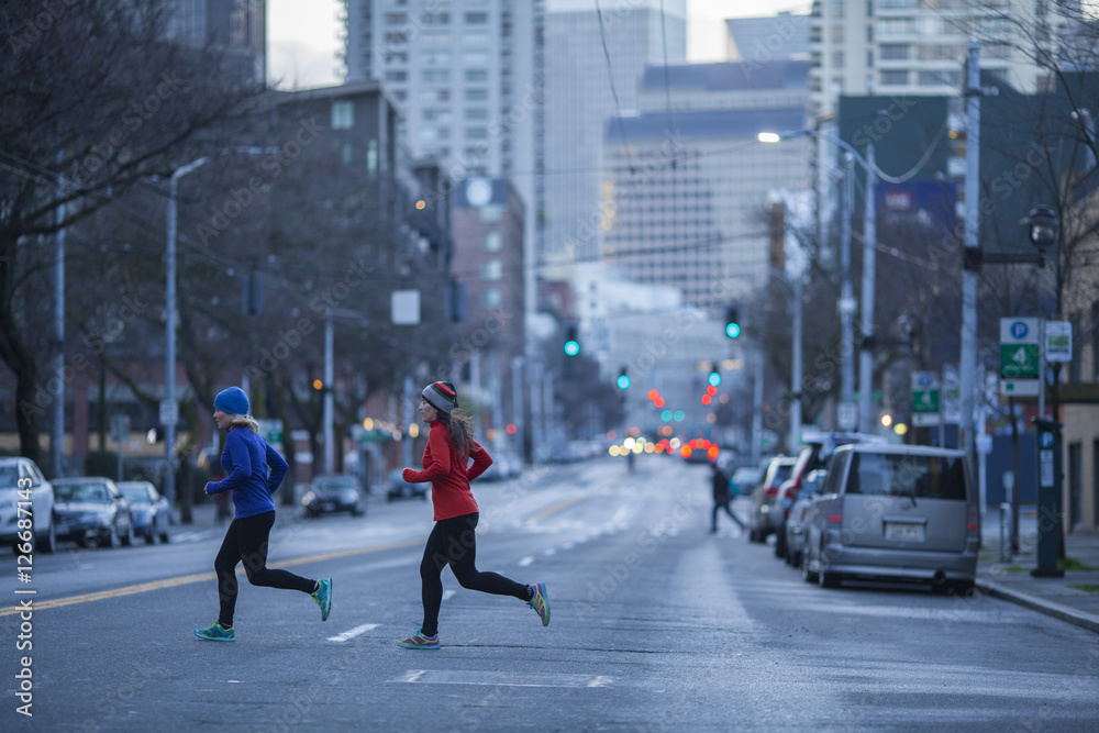 两名成年女性在华盛顿州西雅图街道上奔跑