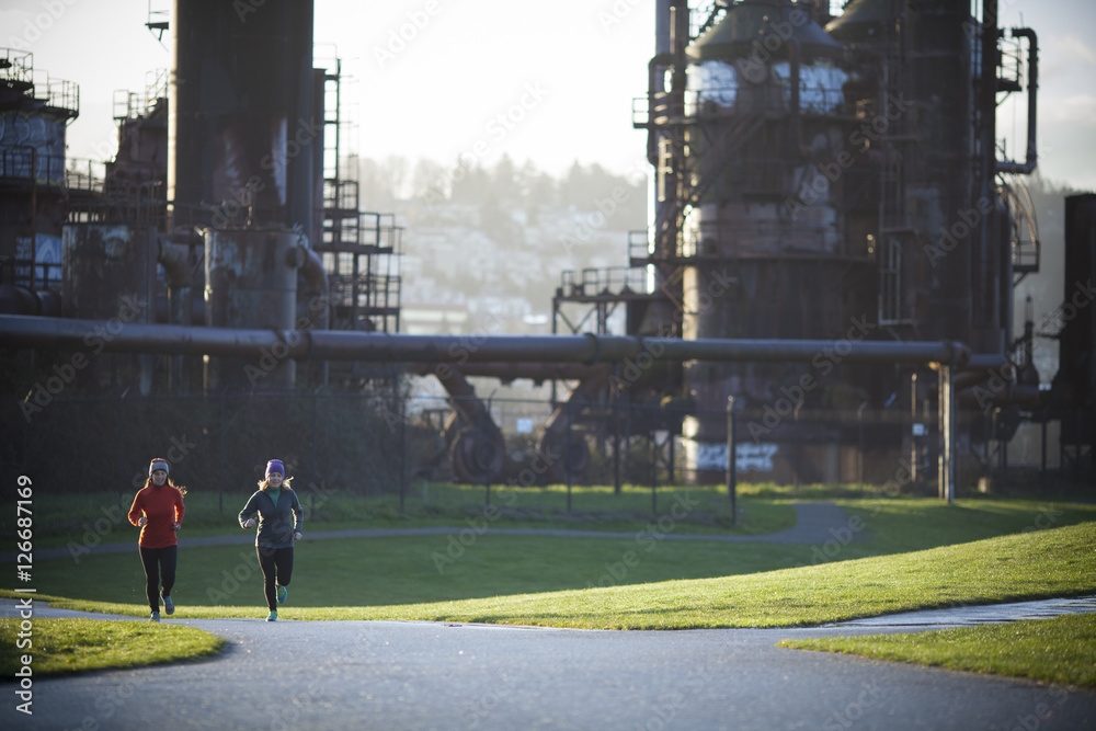 两名成年女性在华盛顿州西雅图的煤气厂公园跑步。