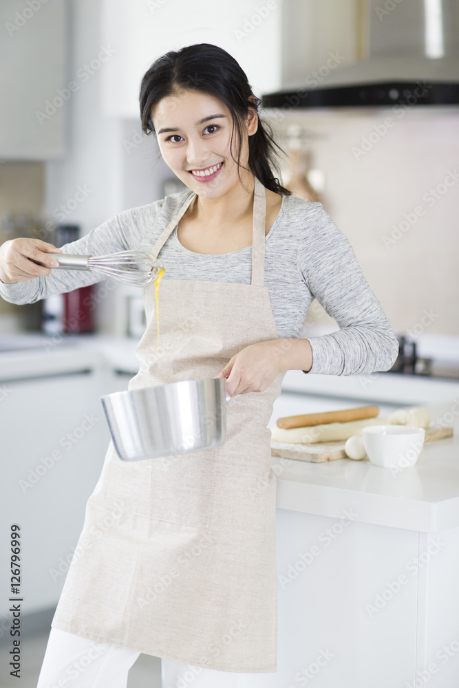 快乐的年轻女人在厨房做饭