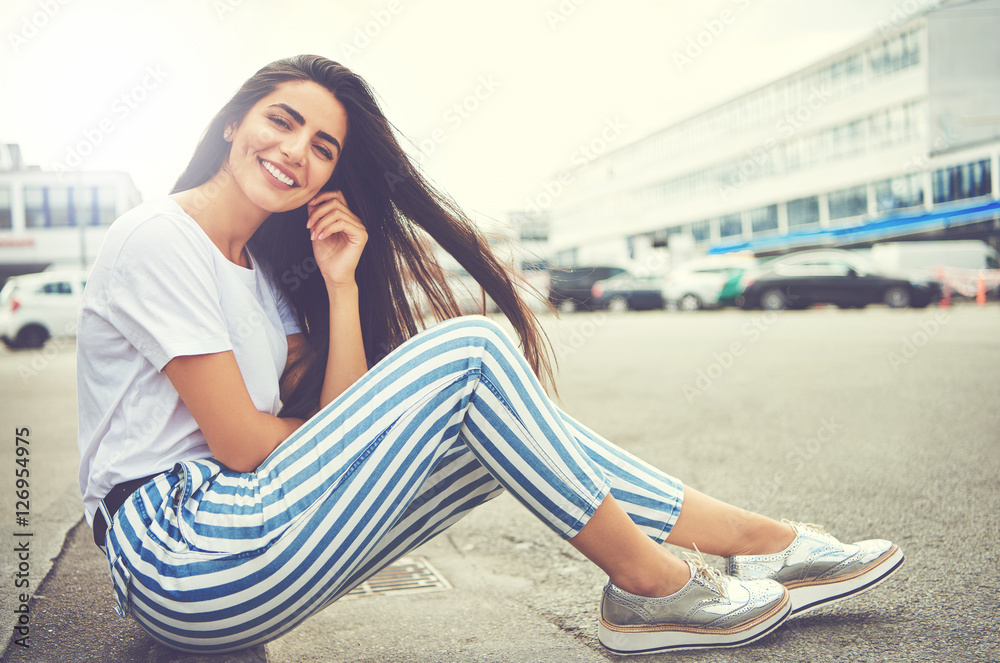 Woman in striped pants and running shoes smiles