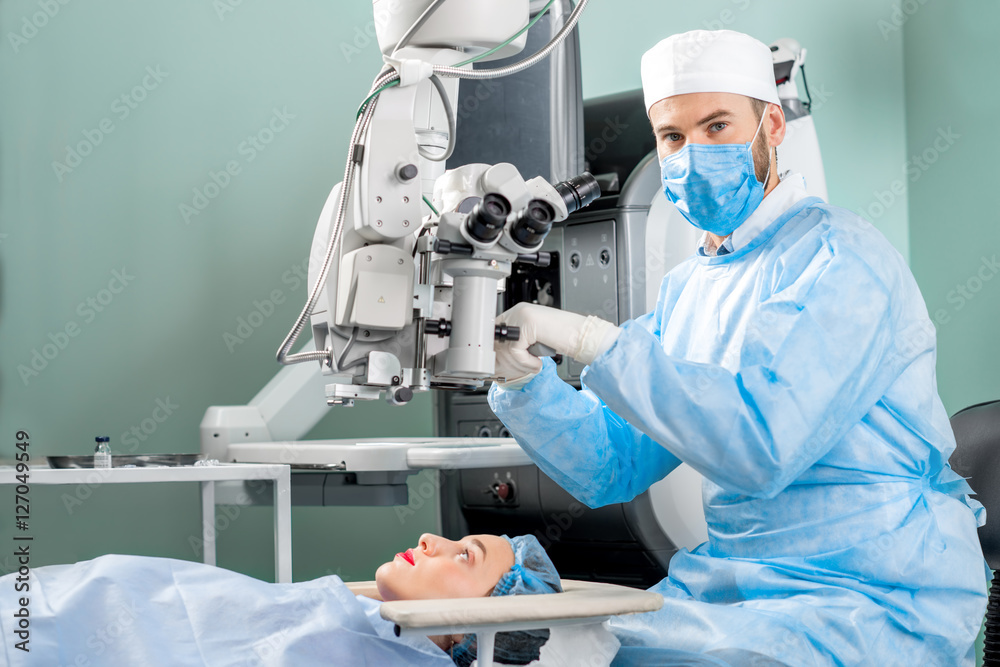外科医生在手术室用显微镜观察女性患者的眼睛