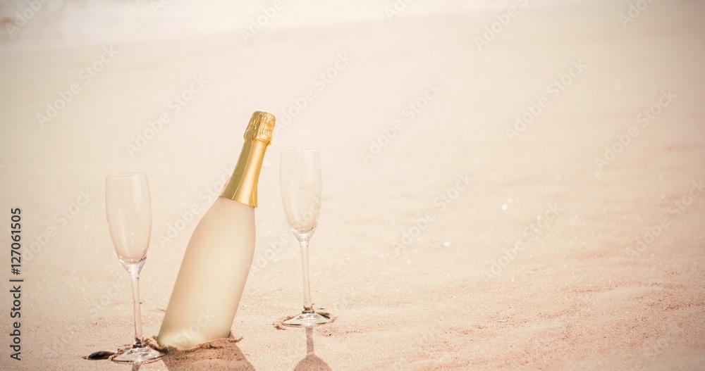 沙滩上的香槟长笛和瓶子