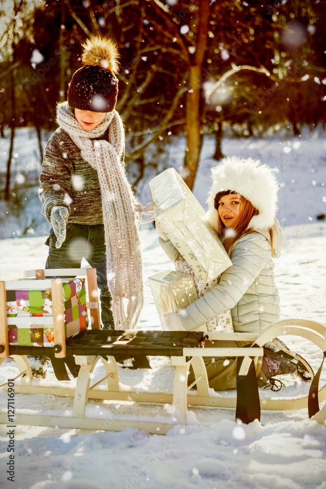 Composite image of brother and sister taking presents by sledge 