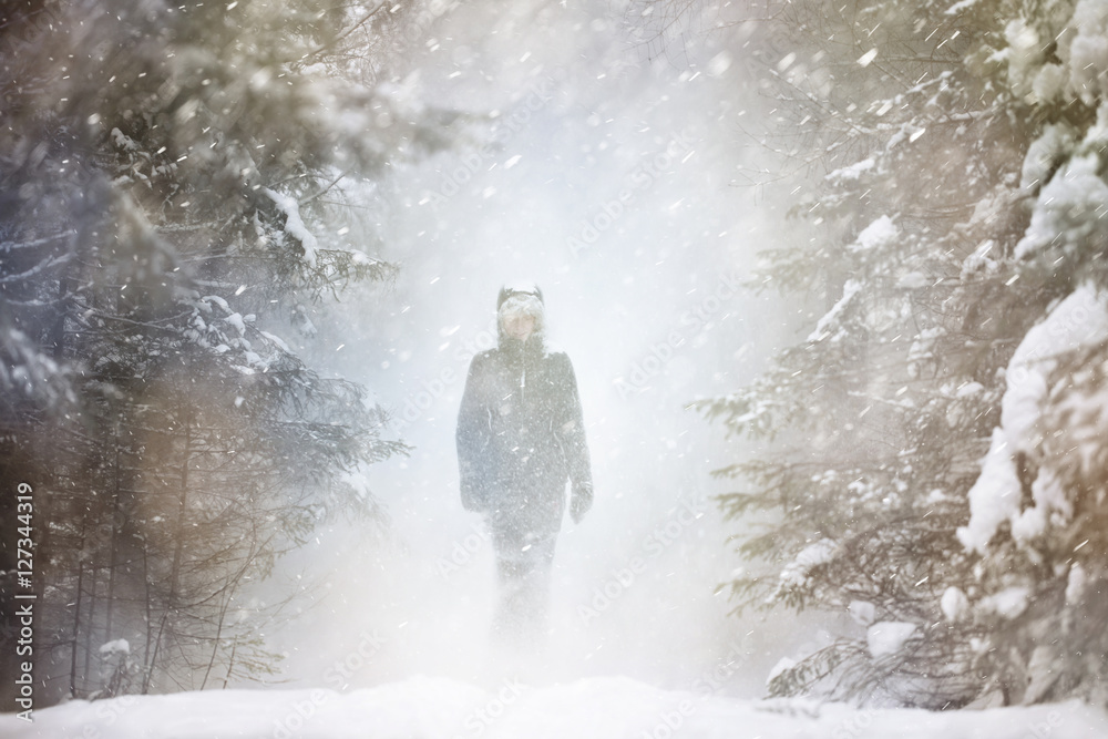 在一个非常寒冷和大雪纷飞的冬天场景中，一个模糊的女人。使用了选择性聚焦。
