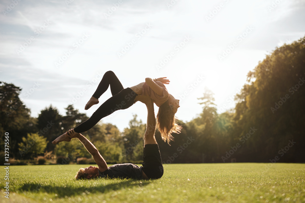 健身情侣在公园做杂技瑜伽运动