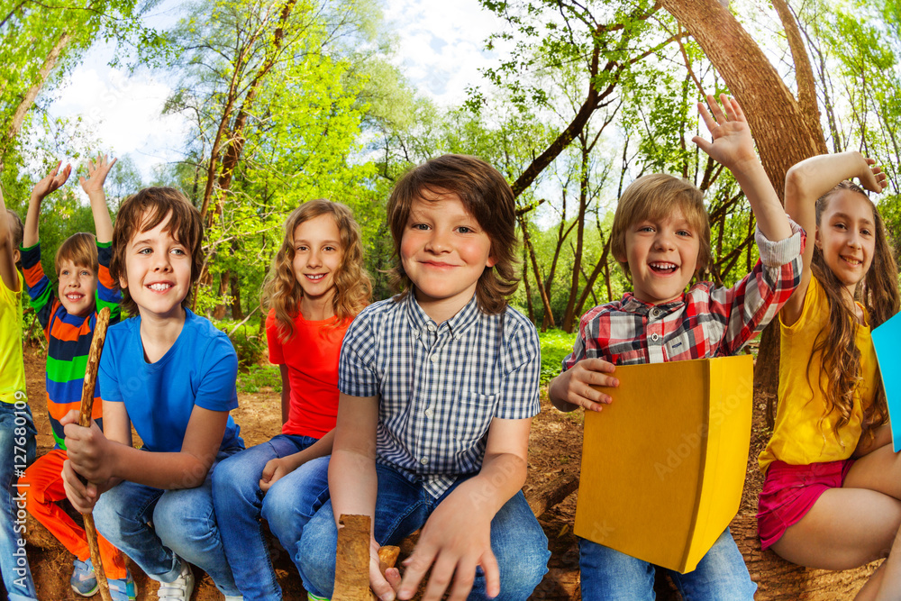 微笑的孩子们在夏日森林里看书