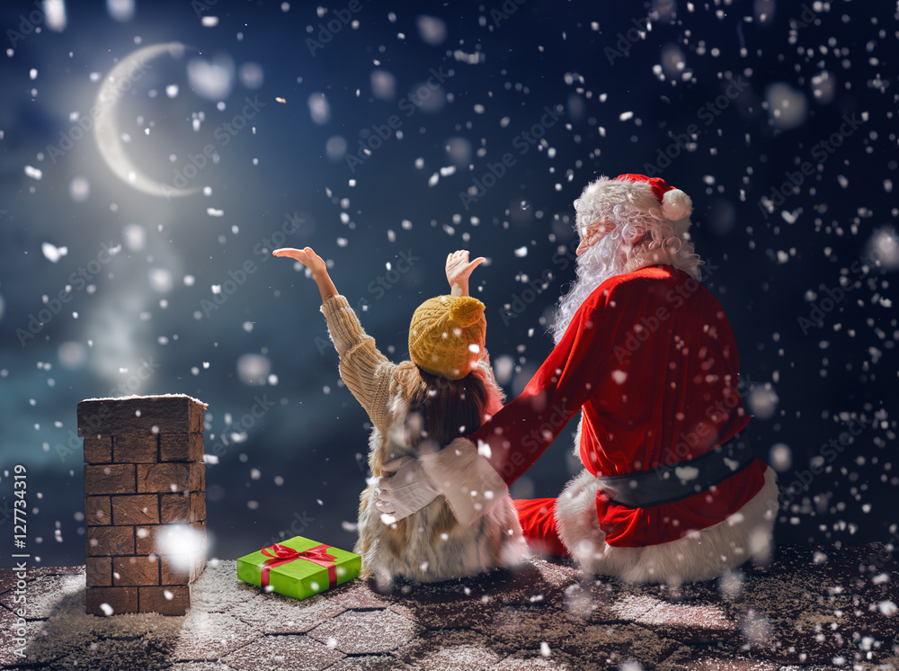 女孩和圣诞老人坐在屋顶上