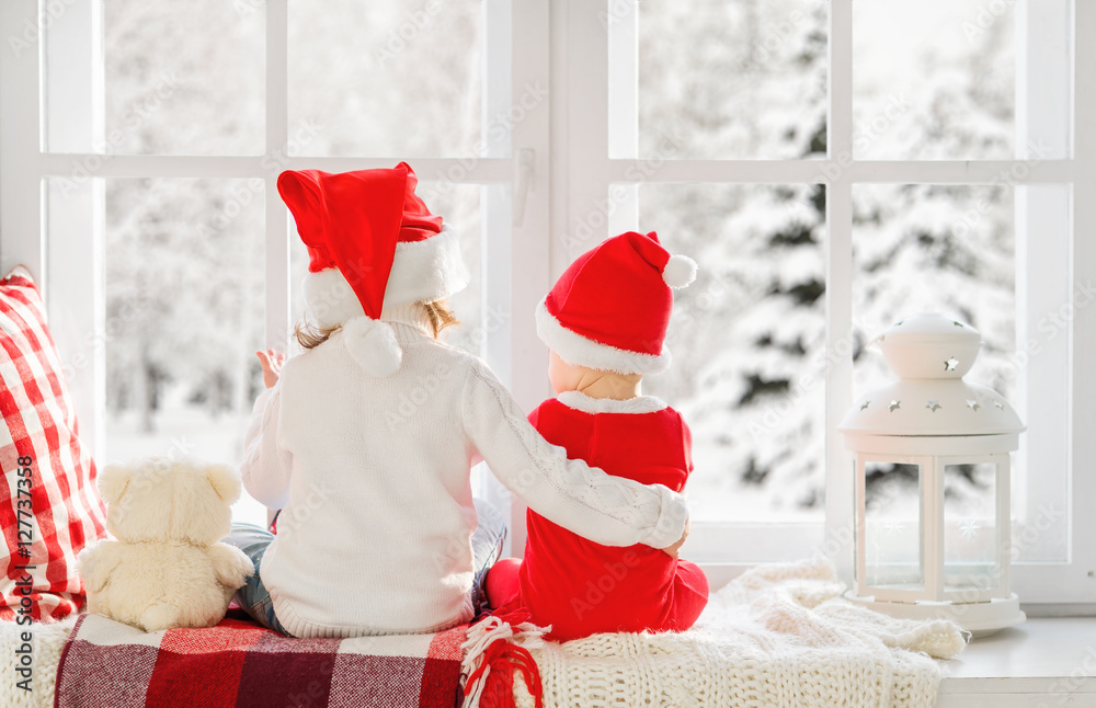 儿童朋友坐在冬窗里过圣诞节