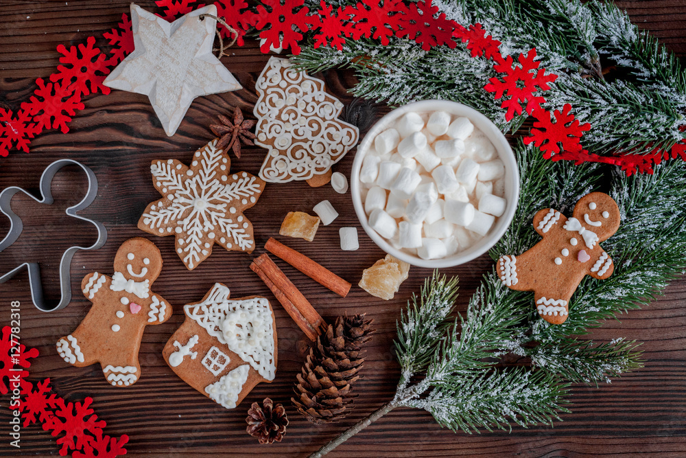 Christmas gingerbread, spruce branches on dark wooden background top view