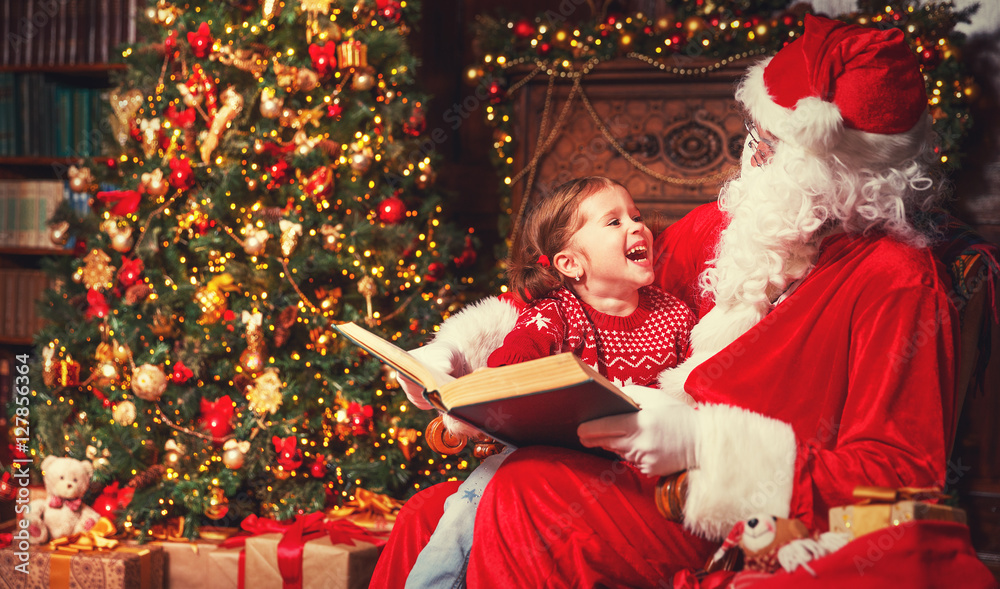 快乐的小女孩和圣诞老人一起读书