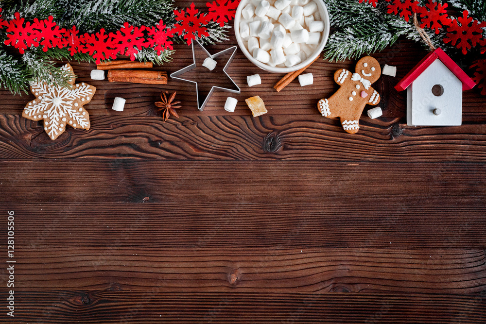 圣诞姜饼，深色木质背景上的云杉树枝俯视图