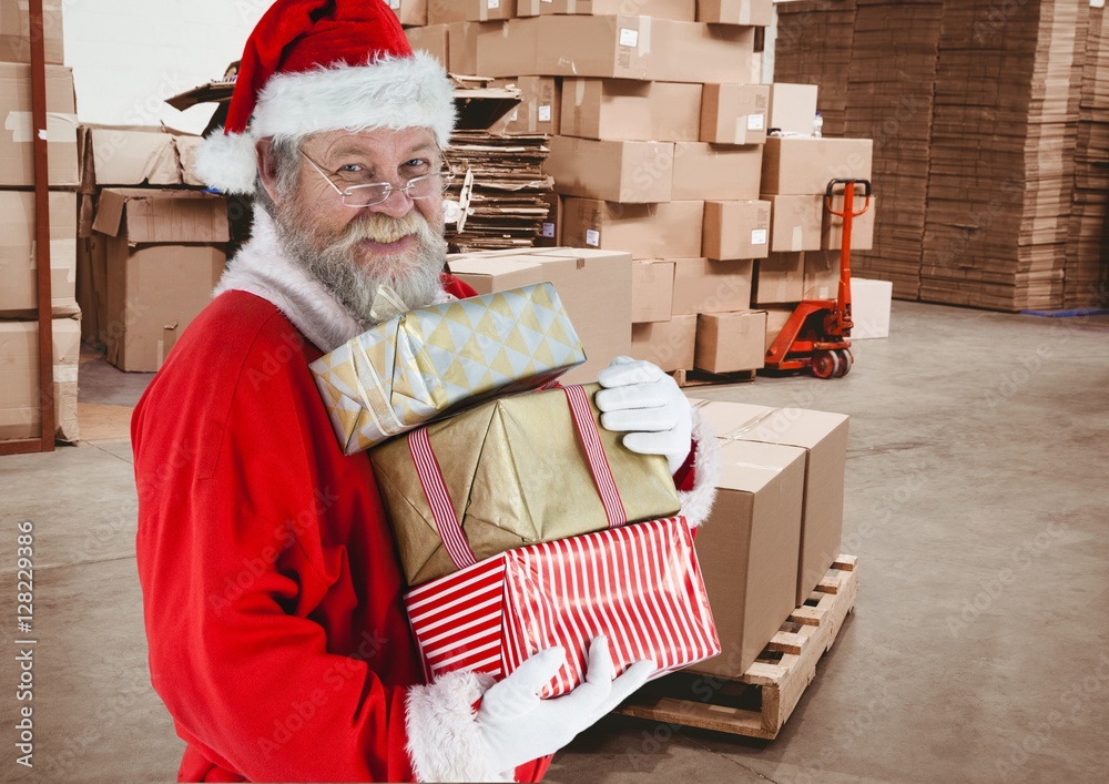 Santa claus holding stack of christmas gifts