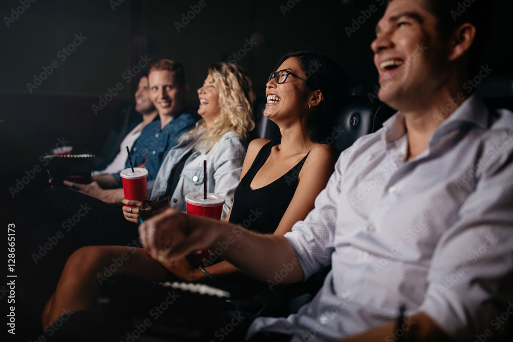 剧院里的年轻人看电影，面带微笑