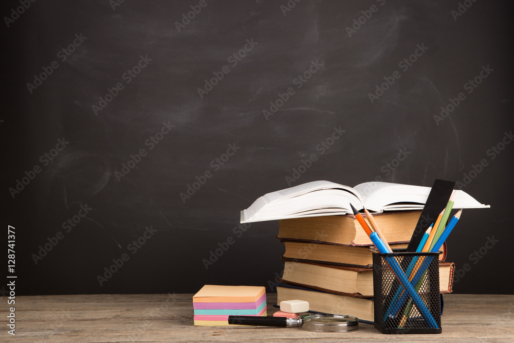 Education concept - books on the desk in the auditorium