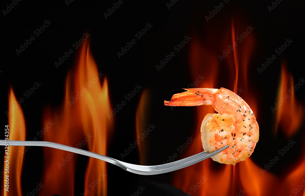 熟虾，火焰背景叉子上的虾