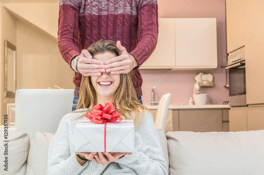 Man keeps his girlfriend eyes covered while she giving a gift , romantic surprise