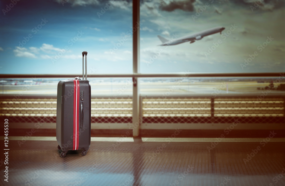 机场候机室的手提箱，背景中的飞机，暑假概念，旅行者sui