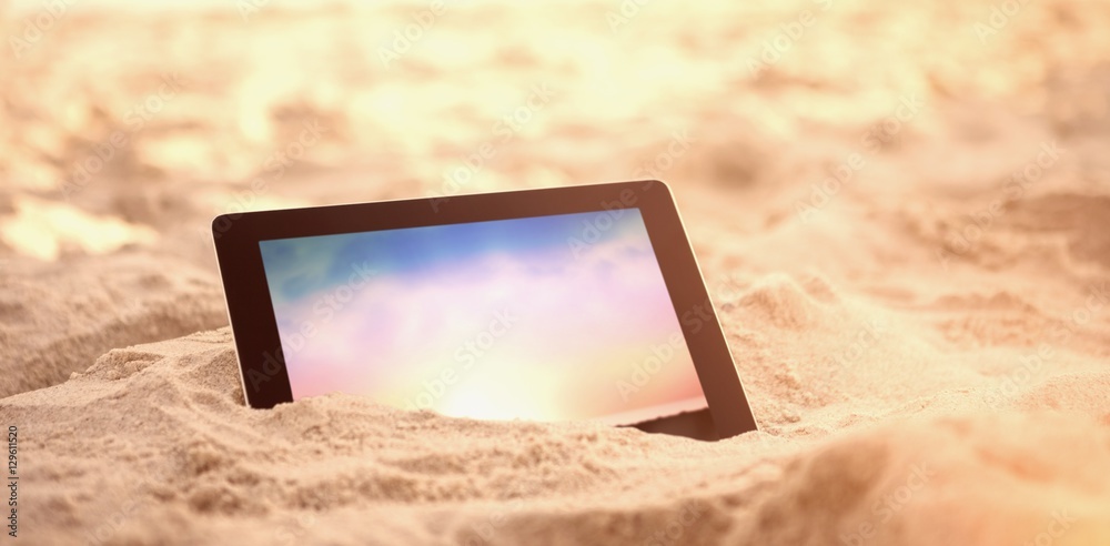保存在海滩沙滩上的数字平板电脑的合成图像