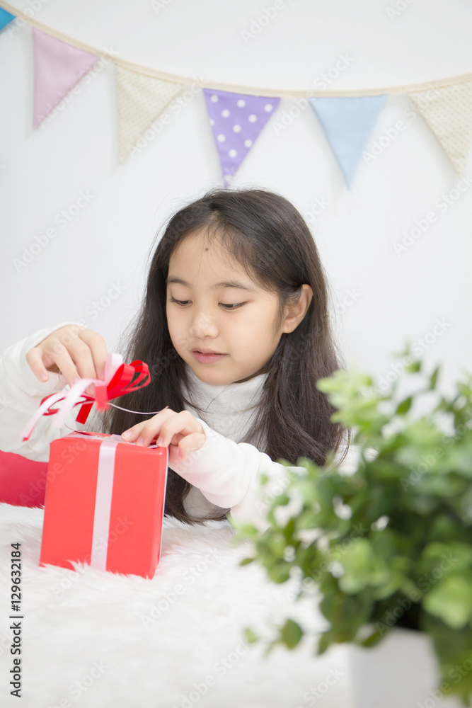 快乐的亚洲女孩打开礼物猜里面是什么