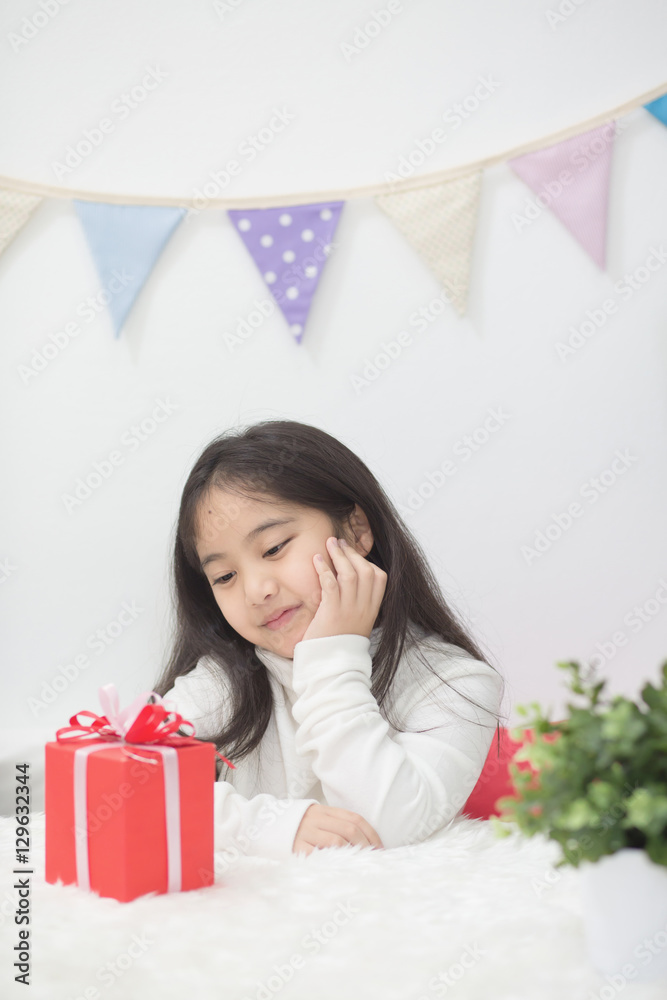 快乐的亚洲女孩在看礼物，猜里面是什么