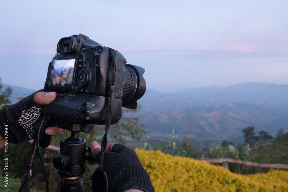 专业景观摄影师调整手头dslr相机的细节。