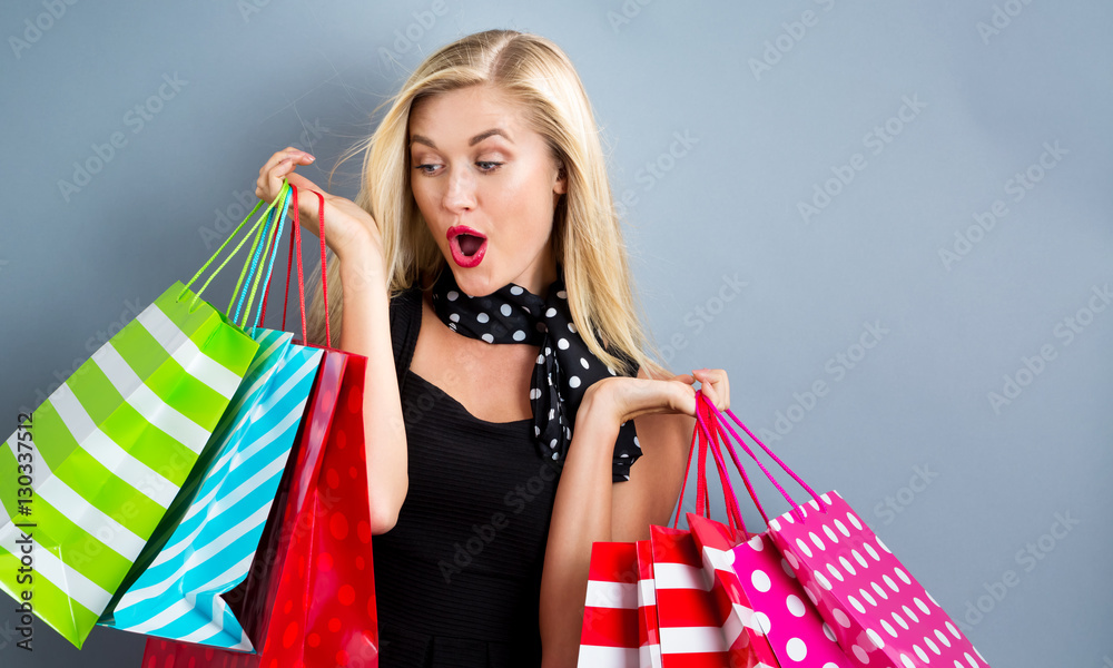 Happy young blonde woman with shopping bags