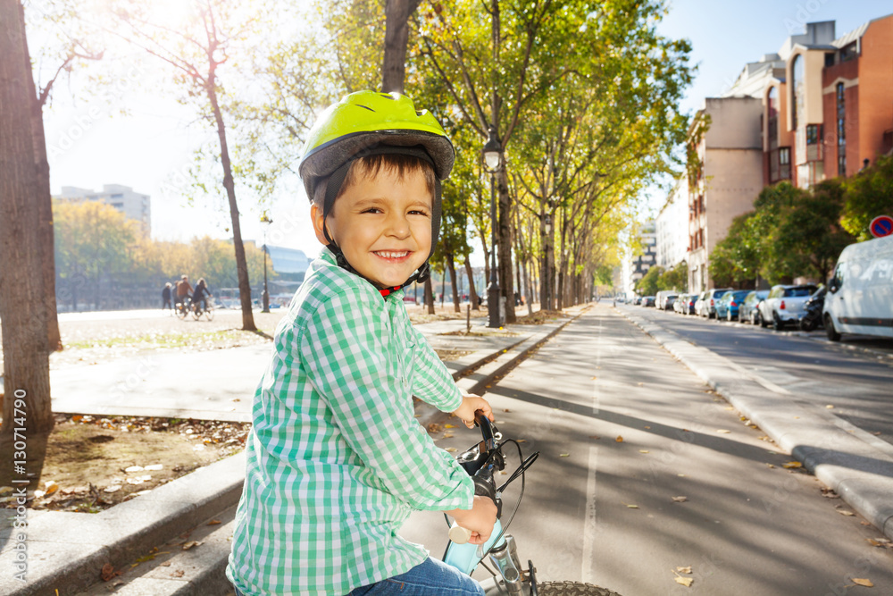 Smiling boy riding his bike on cycle path