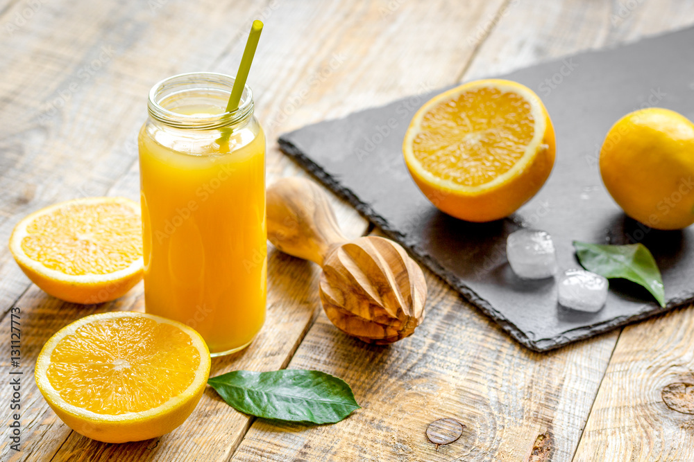 freshly squeezed orange juice in glass bottle on wooden background