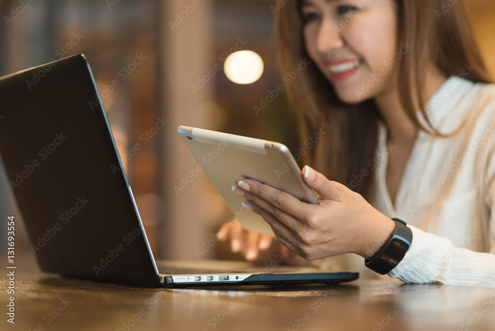 Woman holding tablet  while using laptop, freelance or nadmad wo