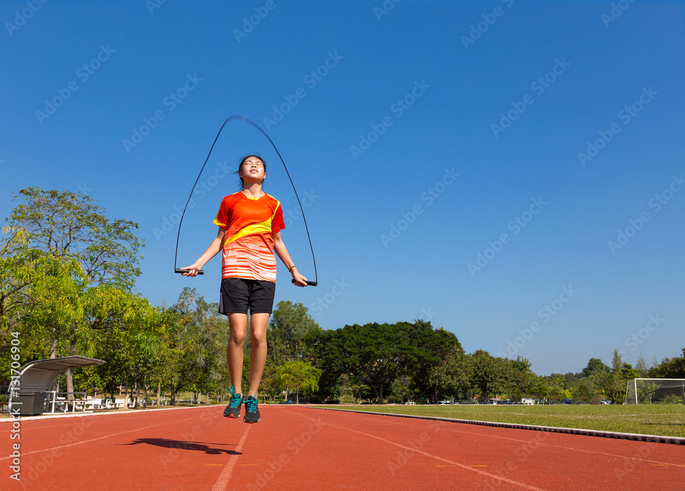 young female asian athlete rope jumping at football, soccer, fie