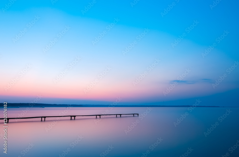 日出时湖面上的老木码头