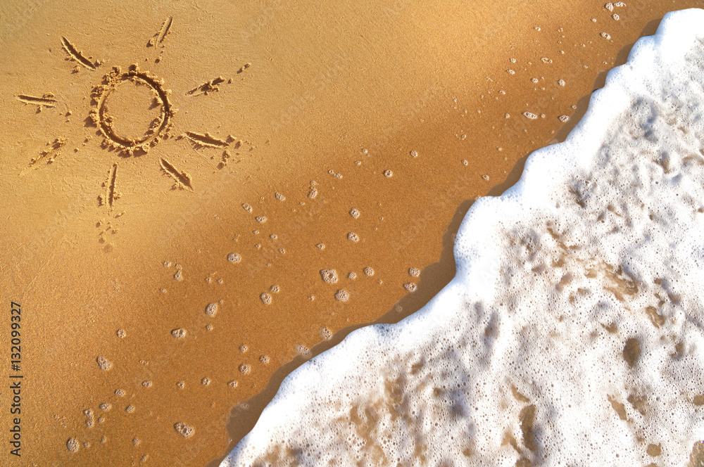 在金色沙滩上绘制的太阳符号，背景是夏季的海浪和泡沫v