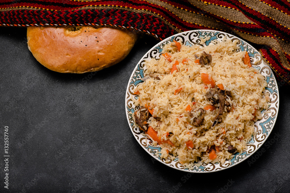 Pilaf on plate with oriental ornament and Traditional Asian breads - churek. Plov. Top view.
