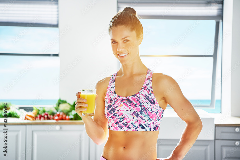 Woman standing with glass of orange juice