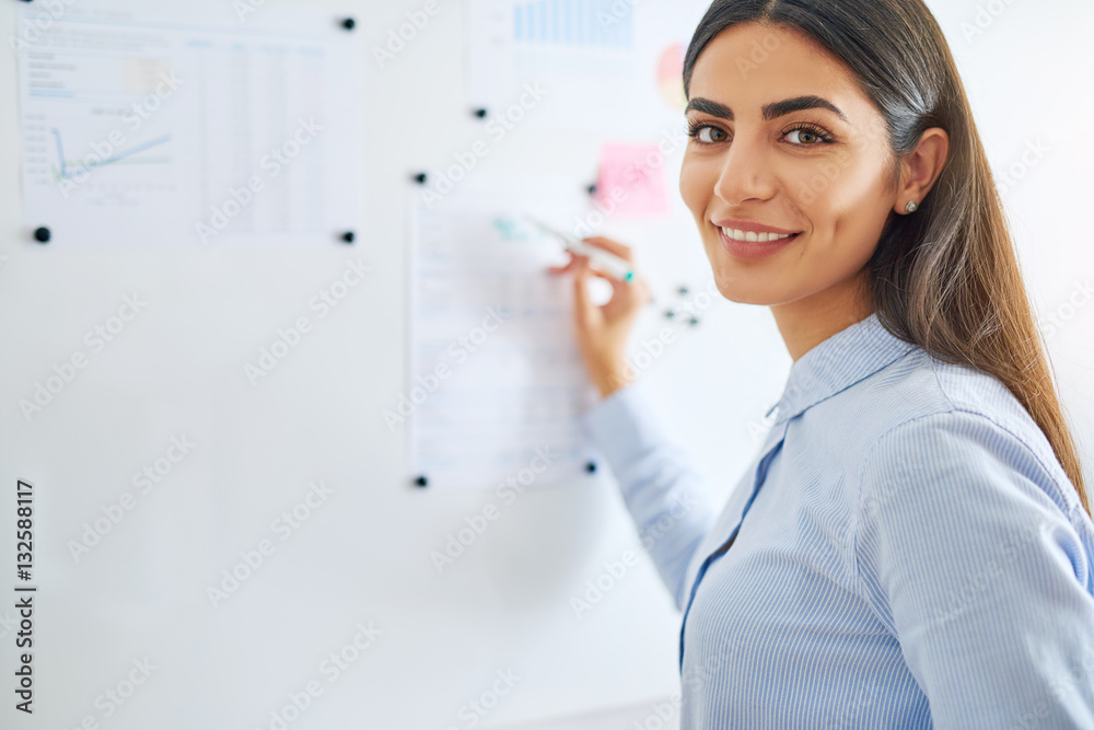 Happy business woman writing on white board