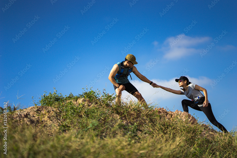 Trail runner are helping women runner from a slope.