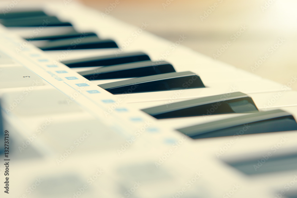 Close up of MIDI controller volume fader, knob and keys.