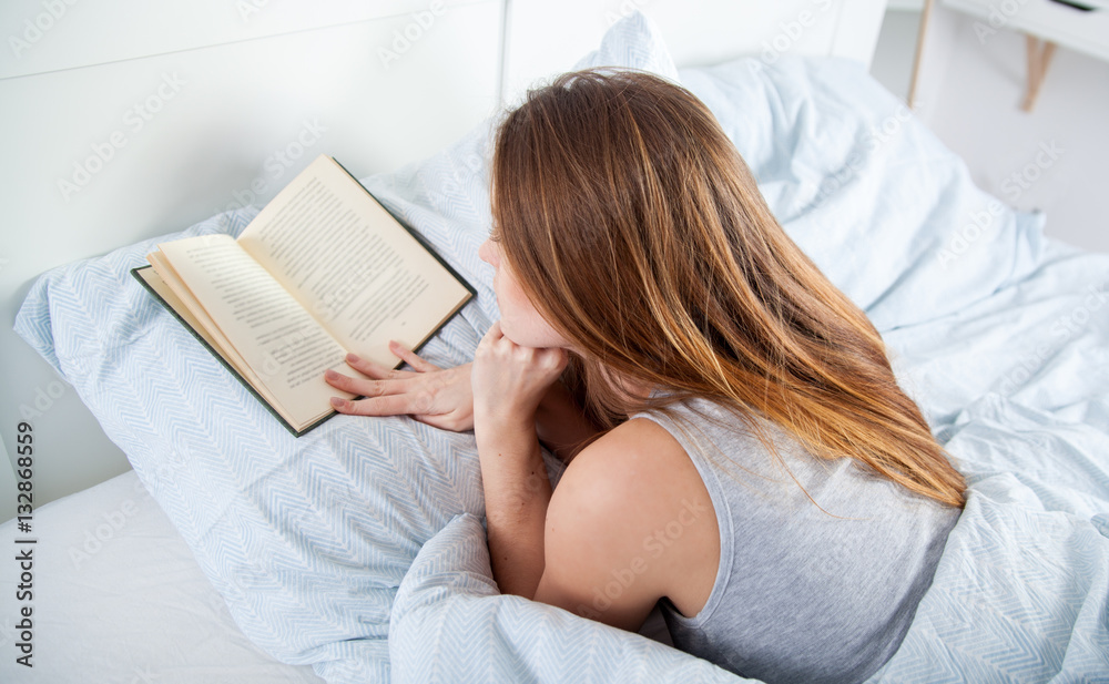 女孩在家躺在床上看书